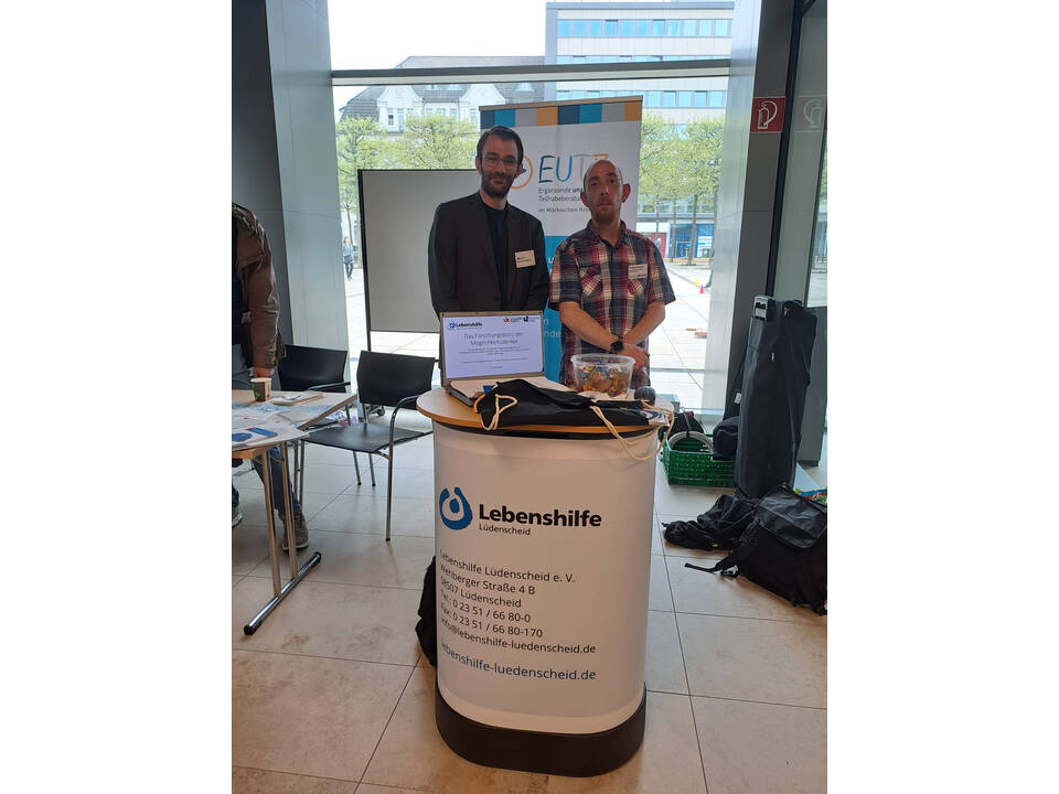 Zwei Personen an einem Informationsstand.