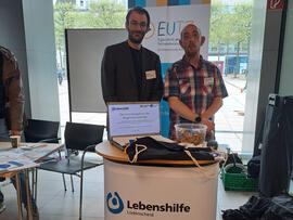 Zwei Personen an einem Informationsstand.
