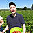 Ein Kunde im Erdbeerfeld mit einer Schüssel Erdbeeren.