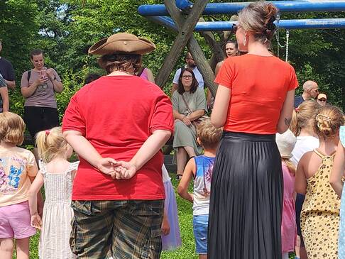 Einige Personen stehen mit Kindern zusammen draussen.