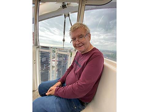 Ein Mann sitzt im Riesenrad.