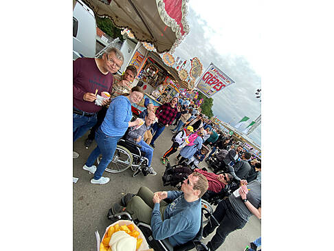Kunden essen etwas auf der Kirmes.