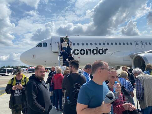 Fluggäste vor einem Flugzeug