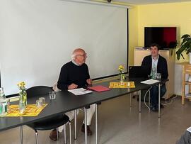 Dr. Schröder und Jörg Bachmann sitzen an einem Tisch.