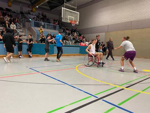 Frauen und Männer mit und ohne Hilfsmittel spielen zusammen Basketball