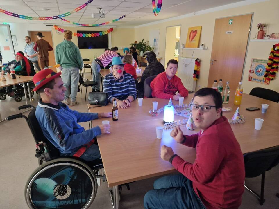 Mehrere Personen in einem geschmückten Raum.