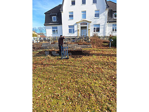 Eine Person arbeitet im Garten.