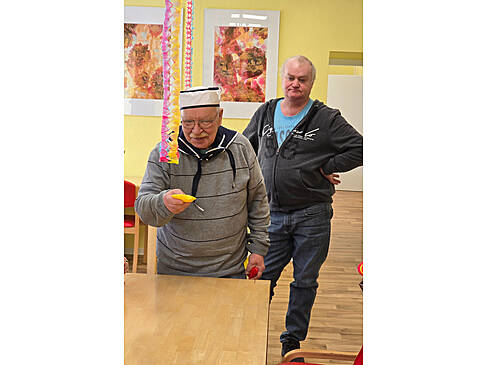 Zwei Personen stehen neben einem Tisch.