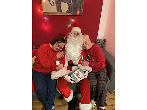 Der Azubi als Nikolaus verkleidet mit zwei Frauen an seiner Seite.
