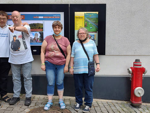Mehrere Personen stehen draussen neben einem Hydranten.