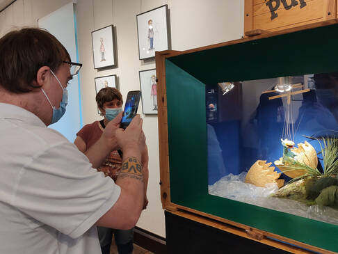 Eine Person macht ein Foto vom Aquarium.