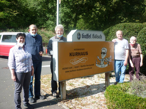 Fünf Personen neben Schild vom Kurhaus.