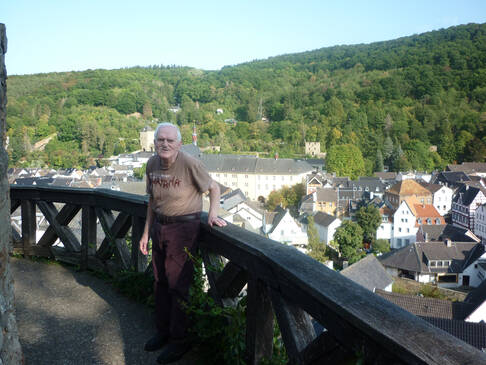 Mann vor Stadtkulisse, er lächelt.
