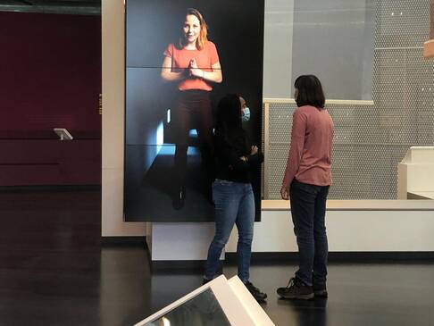 Zwei Frauen stehen vor großem Bild.