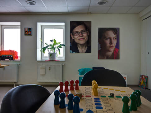 Ein Mensch ärger dich nicht Spiel auf einem Tisch, an der Wand zwei Bilder .