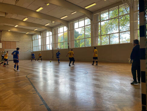 Es wird Fussball in einer Halle gespielt.