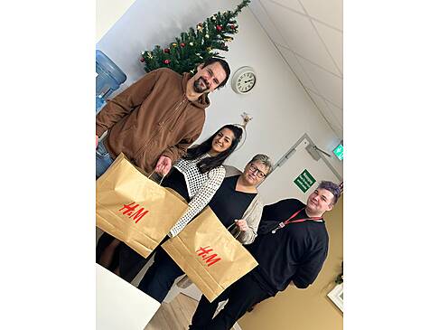 Vier Personen und zwei halten H&M Tüten in der Hand.