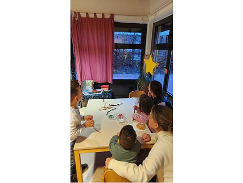 Kinder sitzen an einem Tisch.