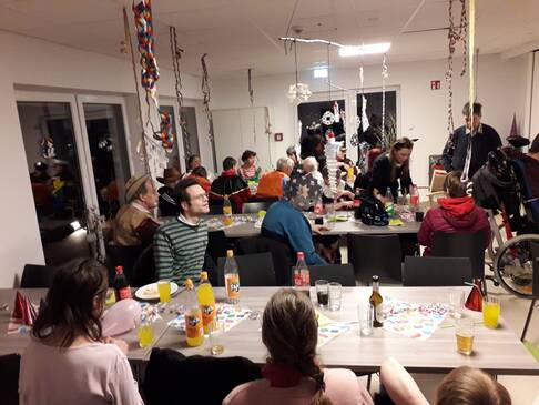 Menschen sitzen verkleidet an Tischen.