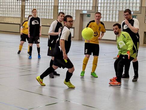 Mehrere Personen die Fussball spielen.