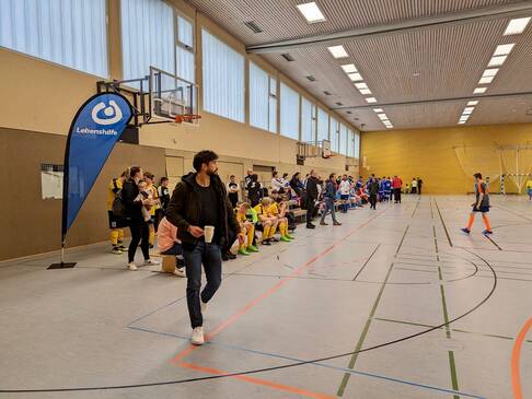 Viele Fussballer und Zuschauer in einer Sporthalle.