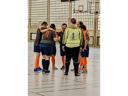 Ein Team steht im Kreis zusammen.