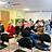 Viele Menschen sitzen in einem Raum und folgen einer Präsentation an der Wand