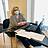 Eine Frau sitzt mit Maske vor einem Laptop am Tisch.