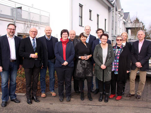 Zwölf Personen stehen nebeneinander.