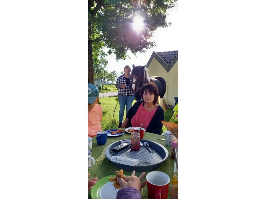 Eine Frau draussen an eine Kaffeetisch.