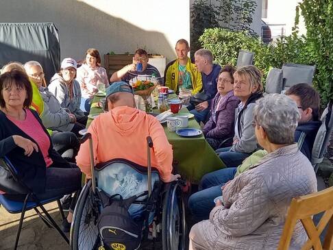 Viele Personen an einem gedeckten Kaffeetisch.