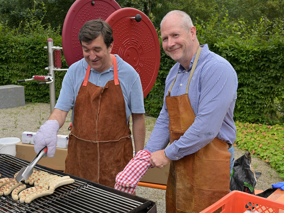 Herr Bachmann und Herr Thiel grillen.