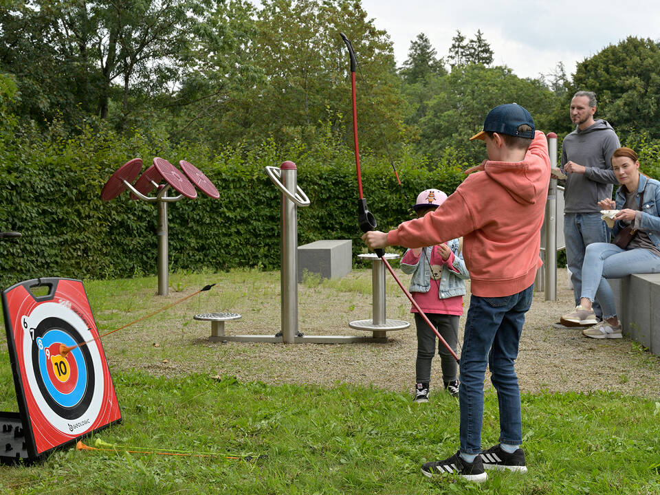Eine Person schießt mit Pfeil und Bogen.