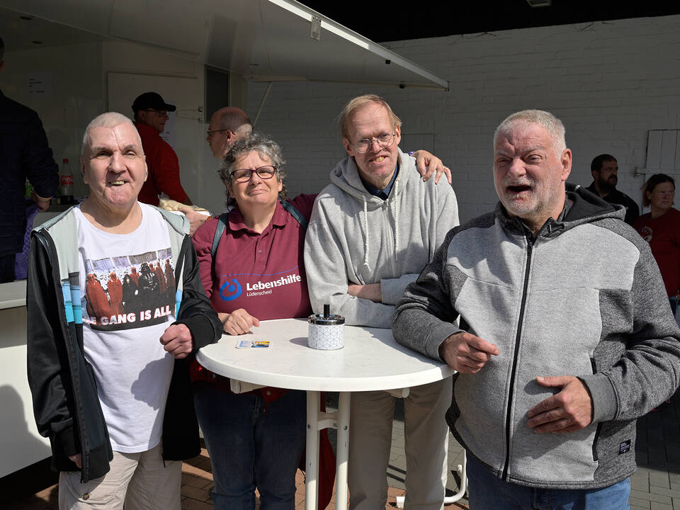 Vier Männer an einem Stehtisch.