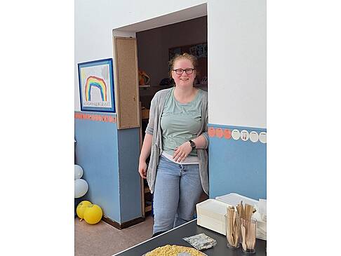 Eine Frau steht im Türrahmen.