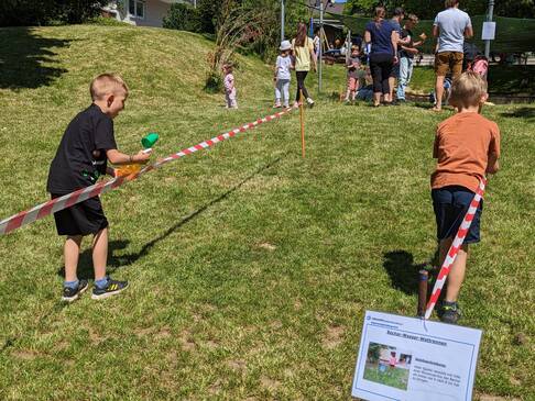 Zwei Kinder gehen direkt neben dem Flatterband entlang einer hat eine Wasserpistole in der Hand.