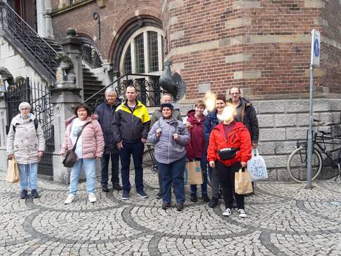 Eine Reisegruppe steht vor einem Gebäude