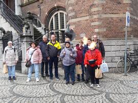 Eine Reisegruppe steht vor einem Gebäude