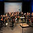 Ein Orchester auf der Bühne, steht.