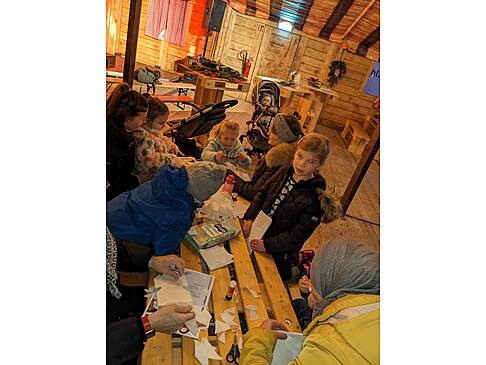 Viele Personen an einem Tisch in der Alm.
