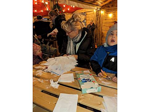 Eine Frau mit Kindern an einem Tisch.