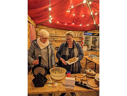 Zwei Frauen backen Waffeln.