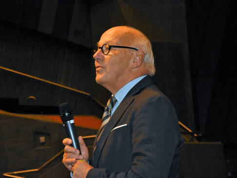 Doktor Schröder mit Mikrofon.