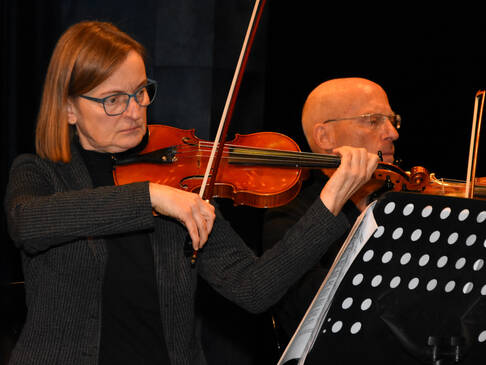 Eine Frau und ein Mann spielen Geige.