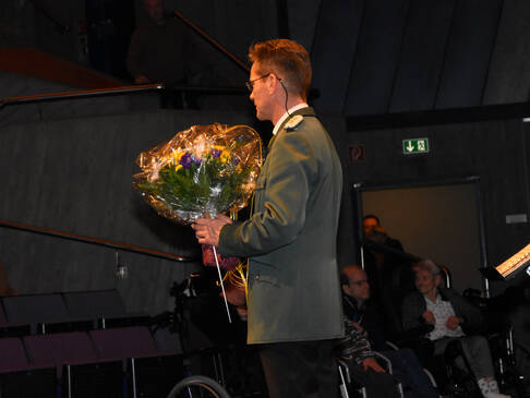 Der Dirigent mit Blumenstrauß in der Hand.