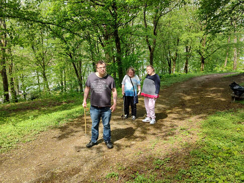 Drei Personen im Wald schauen nach Müll