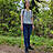 Eine Frau im Wald mit Müllgreifer in der Hand.