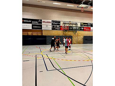 Basketballer mit und ohne Hilfsmittel auf einem Spielfeld.