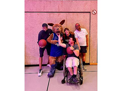 Basketballer mit Maskottchen.