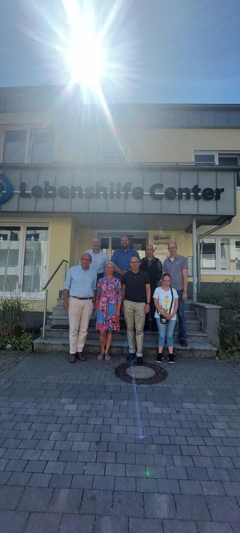 Mehrere Personen stehen mit Herrn Scharzkopf vor dem Lebenshilfe Center.
